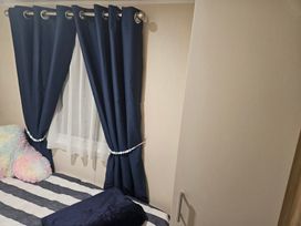 A bedroom featuring curtains window bed and wardrobe at Homeslea 33 Millennium Gardens Morpeth