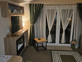 A living room with a TV and fireplace at Homeslea 33 Millennium Gardens in Morpeth