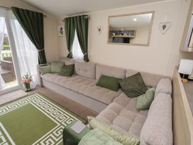 A living room with a sofa and window at Homeslea 33 Millennium Gardens in Morpeth