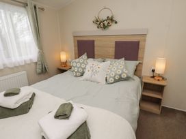 A bedroom with a bed and nightstand at Homeslea 33 Millennium Gardens in Morpeth