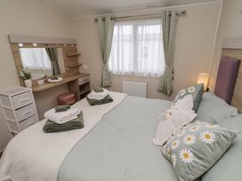 A bedroom with a bed and a dressing table at Homeslea 33 Millennium Gardens in Morpeth