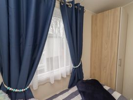 A bedroom with curtains and a wardrobe at Homeslea 33 Millennium Gardens in Morpeth