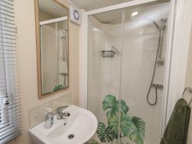 A bathroom featuring a sink, mirror, and shower at Homeslea 33 Millennium Gardens in Morpeth