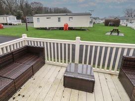A seating area with a table and sofa overlooking a caravan at Homeslea 33 Millennium Gardens Morpeth
