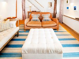 A living room with a sofa and ottoman at Gardeners Cottage in Chipping Norton