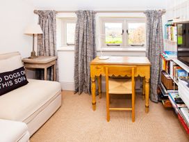A study with a desk and bookshelves at Gardeners Cottage in Chipping Norton