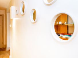 A corridor with shelves and mirrors at Gardeners Cottage in Chipping Norton
