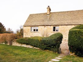 A house with a garden and hedges at Gardeners Cottage in Chipping Norton
