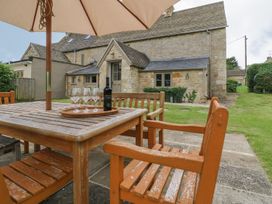 An outdoor dining area with a table and chairs at Gardeners Cottage in Chipping Norton