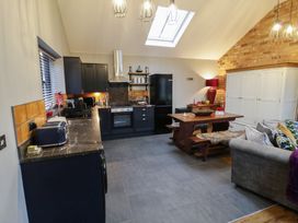 A kitchen with dining table and benches at Otter's Rest in Droitwich