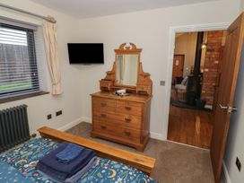 A bedroom with a dresser and TV at Otter's Rest in Droitwich