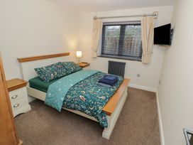 A bedroom with a bed, dresser, and television at Otter's Rest in Droitwich