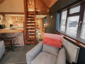 A living room with a staircase and sofa at The Barn on The Lagoon in Droitwich