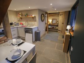 A kitchen with a table and chairs at The Barn on The Lagoon Droitwich