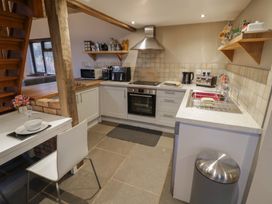 A kitchen with appliances and table at The Barn on The Lagoon Droitwich