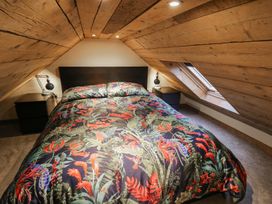 A bedroom with a bed and nightstand at The Barn on The Lagoon Droitwich