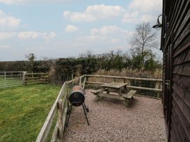 An outdoor area with a picnic table and a barbecue grill at The Barn on The Lagoon Droitwich