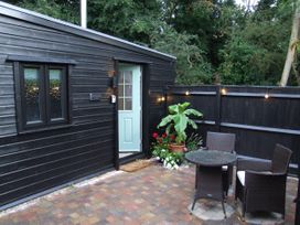 An outdoor area with a door and table at Woodland Lodge The Snug in Filby