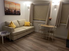 A living room with a sofa and table at Woodland Lodge The Snug Filby