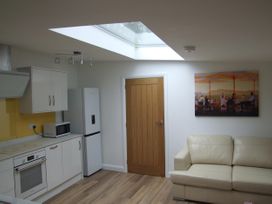 A kitchen with appliances and a sofa at Woodland Lodge The Snug in Filby