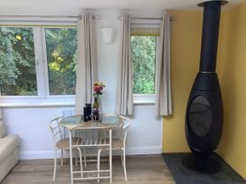 A dining area with a table and chairs at Woodland Lodge The Snug Filby
