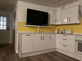 A kitchen with television and appliances at Woodland Lodge The Snug Filby