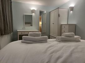 A bedroom with a bed and towels at Woodland Lodge The Snug in Filby