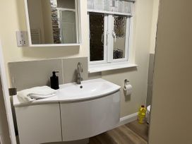 A bathroom with a sink and mirror at Woodland Lodge The Snug Filby