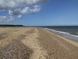 A beach with sand and sea at Woodland Lodge The Snug Filby
