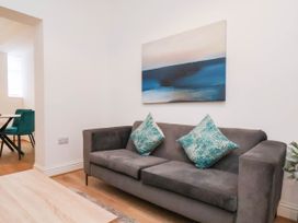A living room with a sofa and wall art at Holmwood