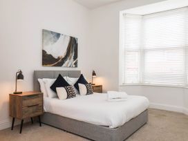 A bedroom with a bed and artwork on the wall at Holmwood