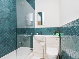 A bathroom with a shower, sink, and toilet at Holmwood