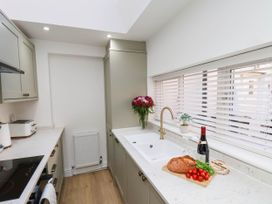 A kitchen with a sink, toaster, and wine bottle at Holmwood