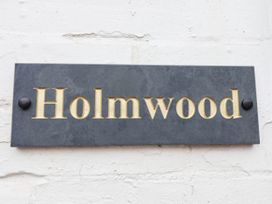 A sign with the name Holmwood displayed on a wall