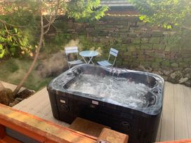An outdoor space with a hot tub, table, and chairs at The Hermitage in Penrith