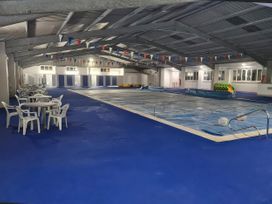 An indoor pool area with tables and chairs at Chalet 58 California, Norfolk