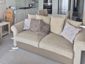 A living room with a sofa and kitchen in view at 21 Gorse Hill, Exmouth