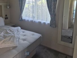 A bedroom with a bed and window at 21 Gorse Hill Exmouth