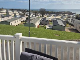 A view of caravans and grass overlooking the sea at 21 Gorse Hill, Exmouth