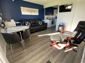 A living room with a table and chairs at Chalet 333 in California, Norfolk