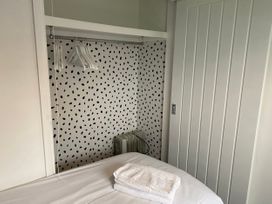 A bedroom with a hanging rail and towels at Chalet 333, California, Norfolk