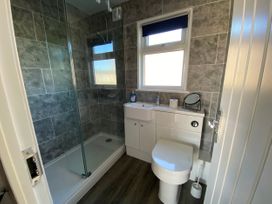 A bathroom with shower, toilet, sink and mirror at Chalet 333, California, Norfolk