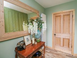A hallway with a wooden table and flowers in a vase at The Stable in Dublin
