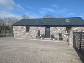 A stone building with a green door and potted plants at The Stable Swords, County Dublin