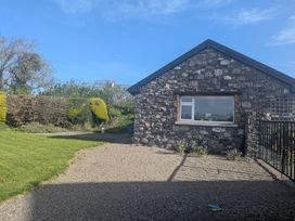 A house with a stone wall and grass area at The Stable in Swords, County Dublin