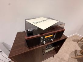 A turntable on a wooden cabinet in the living room at Amber Rose Berwick-upon-Tweed