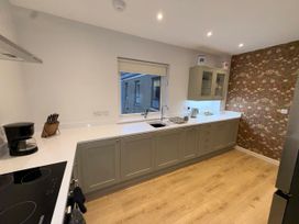 A kitchen with cabinets, sink, and cooking appliances at Amber Rose in Berwick-upon-Tweed