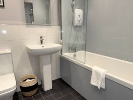 A bathroom with a sink, toilet, bathtub, and shower at Amber Rose in Berwick-upon-Tweed