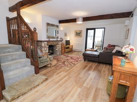 A living room with a sofa and fireplace at Ivy Cottage in Abergele