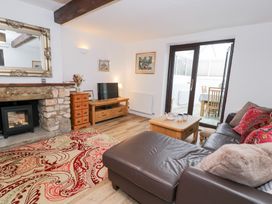 A living room with a sofa and television at Ivy Cottage in Abergele